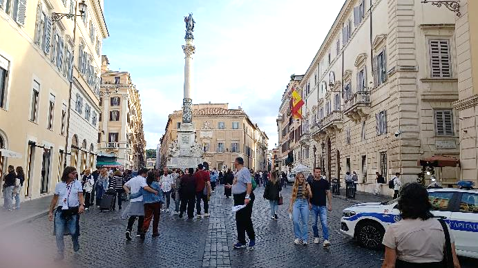 Un grupo de personas caminando en una plaza con gente y edificios de fondo

El contenido generado por IA puede ser incorrecto.